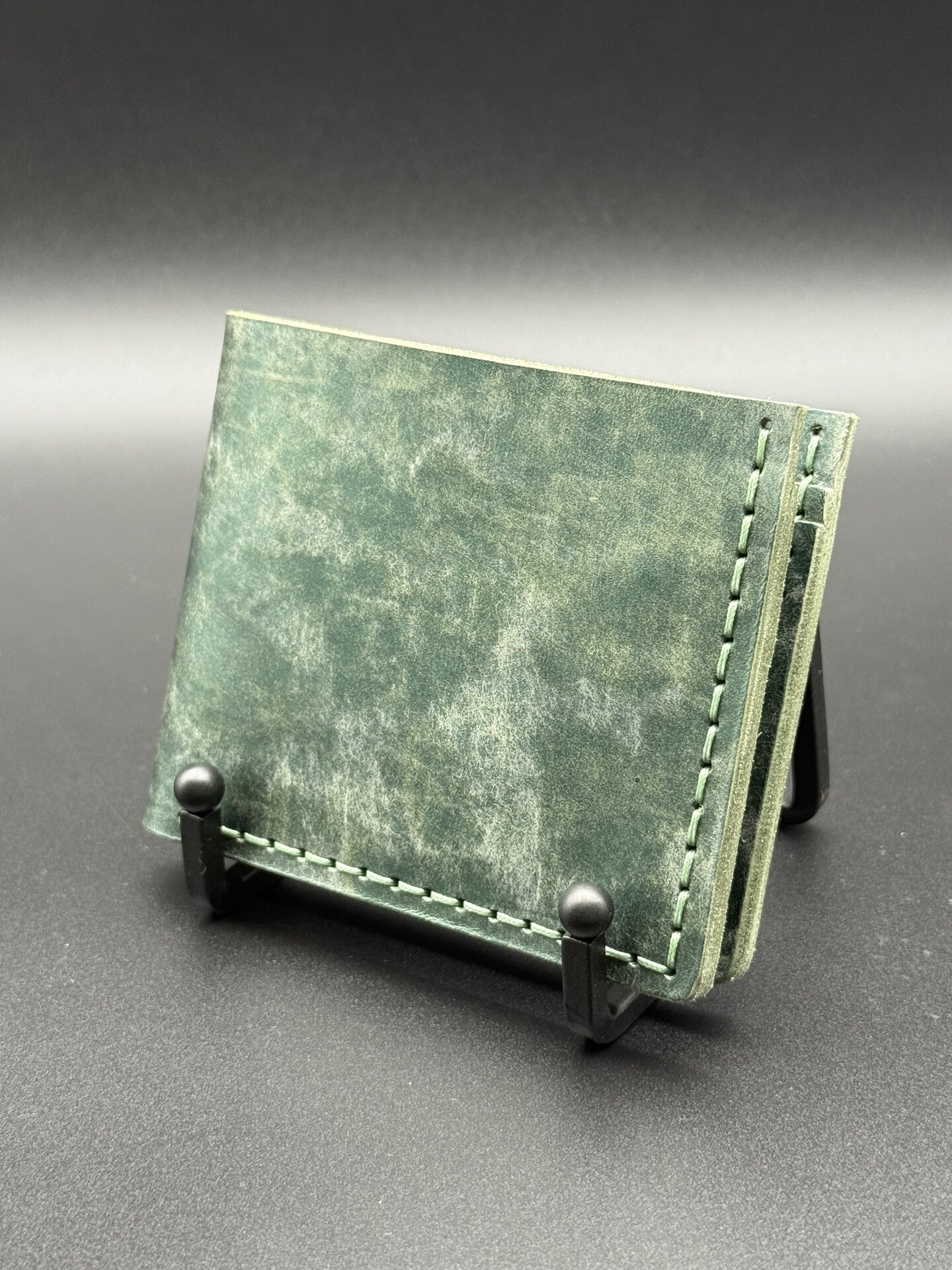 Bifold leather wallet in Rustic Metallic Emerald Bisanzio leather with light green stitching